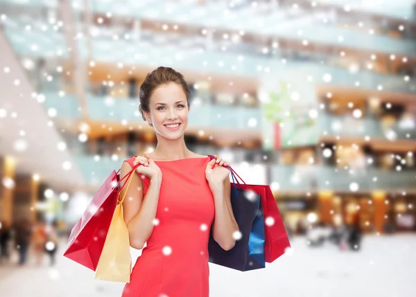 Mulher sorridente com sacos de compras coloridos — Fotografia de Stock