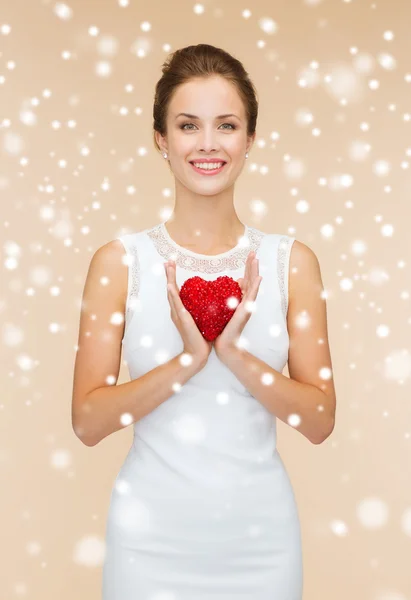 Mulher sorridente em vestido branco com coração vermelho — Fotografia de Stock