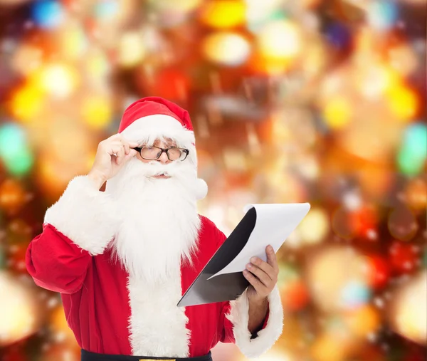 Man in costume of santa claus with notepad — Stock Photo, Image