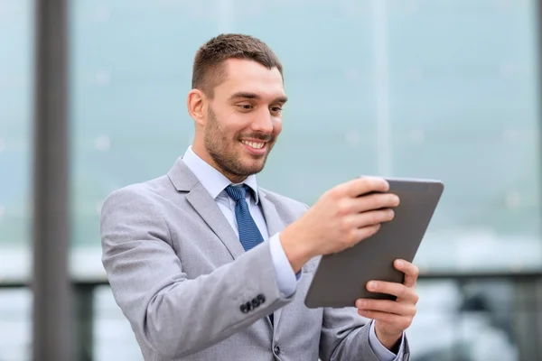 Uomo d'affari sorridente con tablet pc all'aperto — Foto Stock