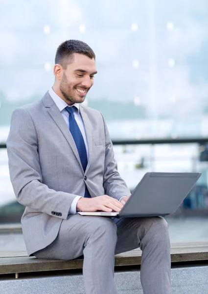 Lächelnder Geschäftsmann, der draußen mit Laptop arbeitet — Stockfoto