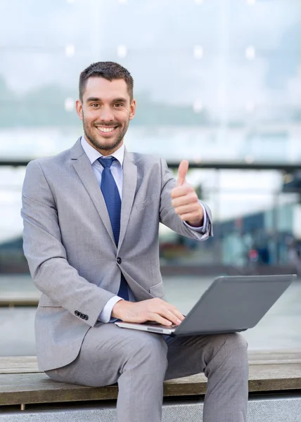 Lächelnder Geschäftsmann, der draußen mit Laptop arbeitet — Stockfoto