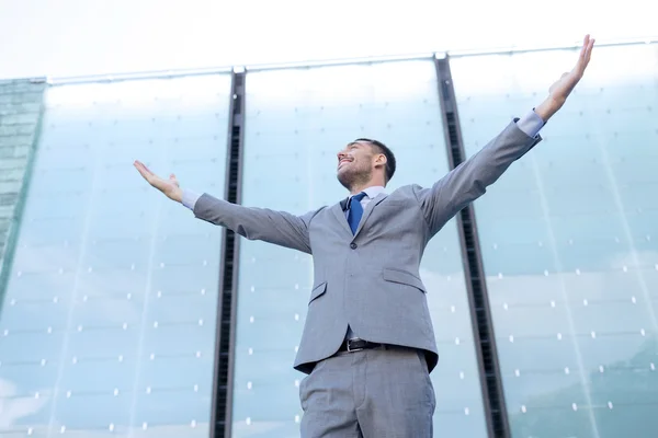 Jeune homme d'affaires souriant sur immeuble de bureaux — Photo