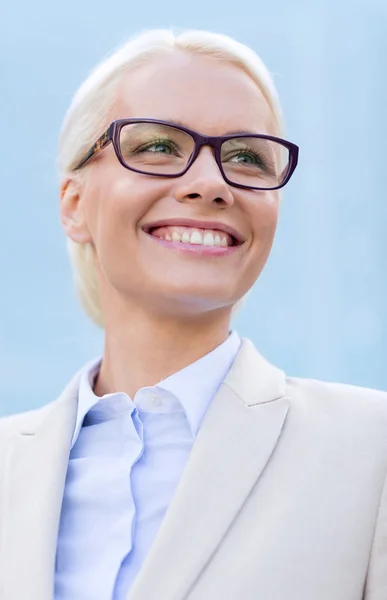 Joven mujer de negocios sonriente sobre edificio de oficinas — Foto de Stock