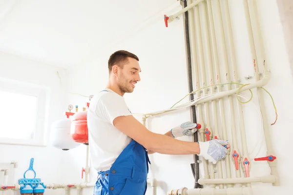 Sonriente constructor o fontanero trabajando en interiores — Foto de Stock