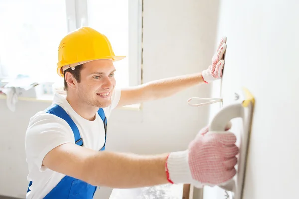 Smiling builder with grinding tool indoors — Stock Photo, Image