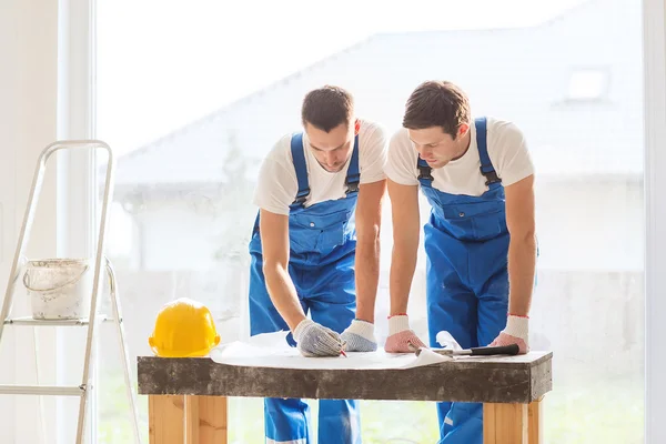 Group of builders with blueprint — Stock Photo, Image