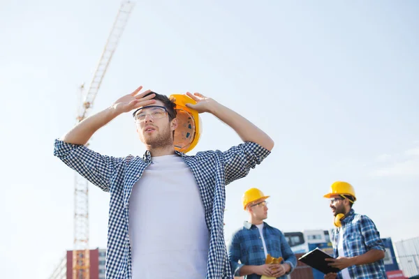 Grupa budowniczych w hardhats na zewnątrz — Zdjęcie stockowe