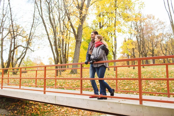 Couple souriant étreignant sur le pont dans le parc d'automne — Photo