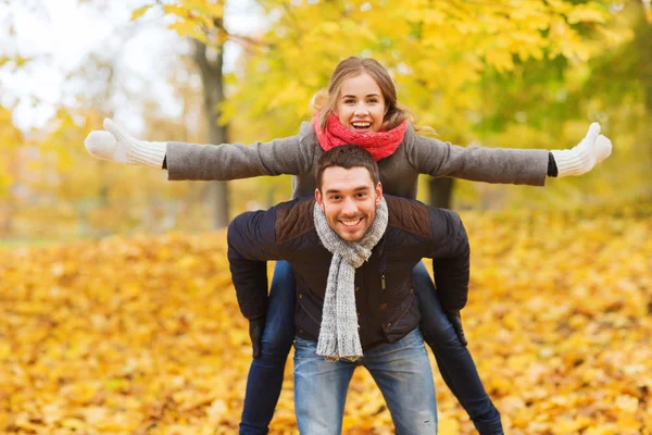 Sonriente pareja divirtiéndose en el parque de otoño —  Fotos de Stock