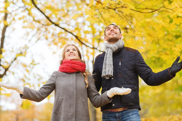 Coppia sorridente guardando in su nel parco di autunno — Foto Stock