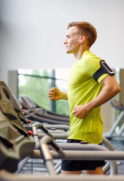 在健身房的跑步机上锻炼的男人微笑着 — 图库照片