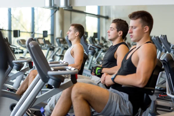 men working out on exercise bike in gym - Stock Image - Everypixel