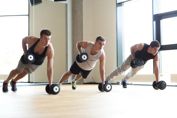 Gruppo di uomini con manubri in palestra — Foto Stock