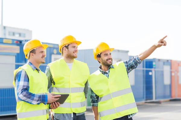 Lächelnde Bauarbeiter in Harthüten mit Tablet-PC — Stockfoto