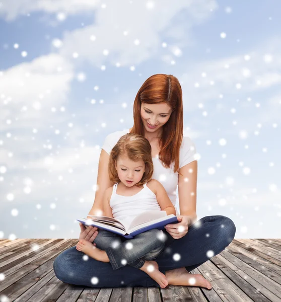 Madre feliz con niña y libro —  Fotos de Stock