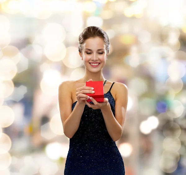 Mujer sonriente sosteniendo caja de regalo roja — Foto de Stock