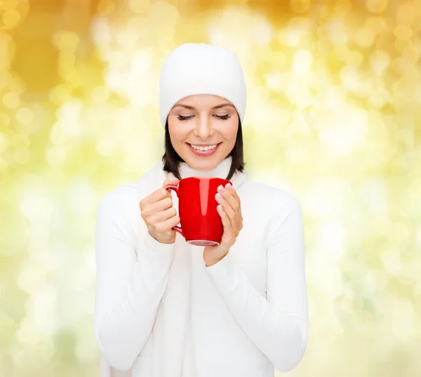 Sonriente mujer joven en ropa de invierno con taza — Foto de Stock