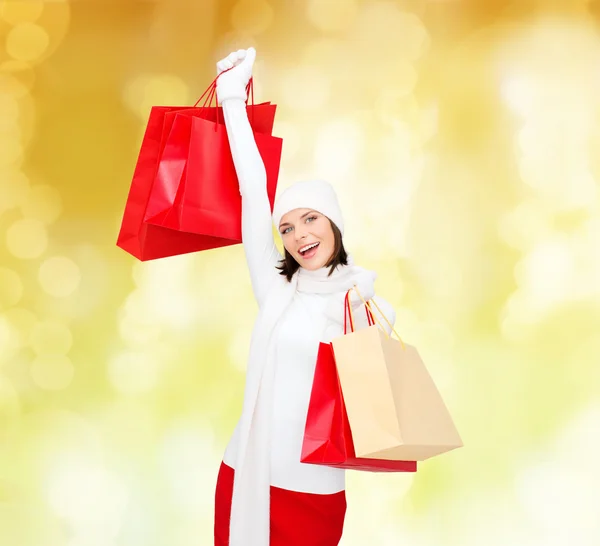 Sorrindo jovem mulher com sacos de compras vermelhos — Fotografia de Stock