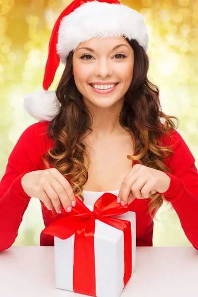 Mujer sonriente en sombrero de ayudante de santa con caja de regalo —  Fotos de Stock