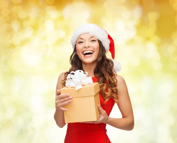 Mujer sonriente en sombrero de ayudante de santa con caja de regalo — Foto de Stock