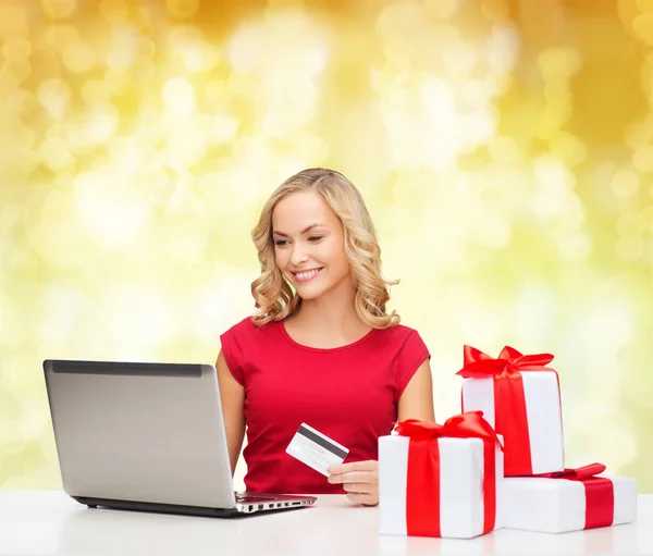 Mulher sorridente com cartão de crédito e laptop — Fotografia de Stock