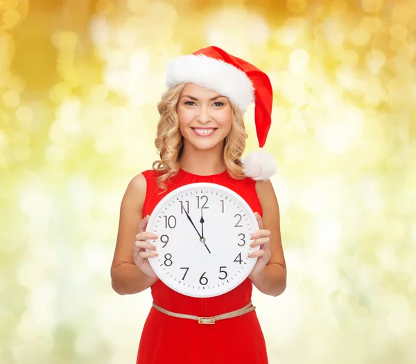 Donna sorridente in cappello Babbo Natale con orologio — Foto Stock