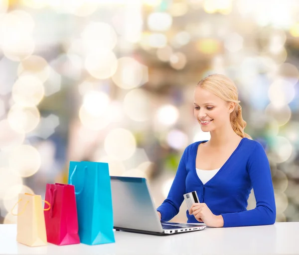 Mulher sorridente com cartão de crédito e laptop — Fotografia de Stock