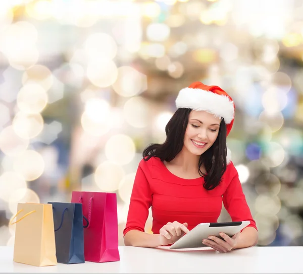 Mulher sorridente com sacos de compras e tablet pc — Fotografia de Stock