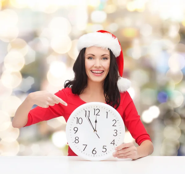 Lachende vrouw in helper kerstmuts met klok — Stockfoto