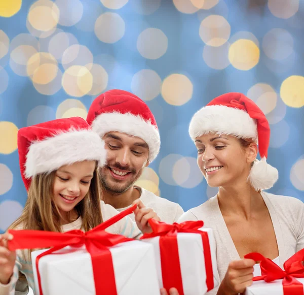 Щаслива сім'я в капелюхах Санта помічника з подарунковими коробками — стокове фото