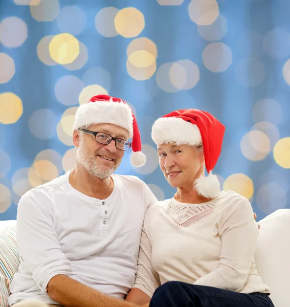 Счастливая старшая пара в шляпах помощников Санты — стоковое фото