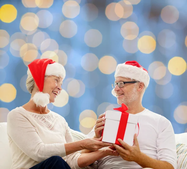 Glückliches Seniorenpaar mit Geschenkbox zu Hause — Stockfoto