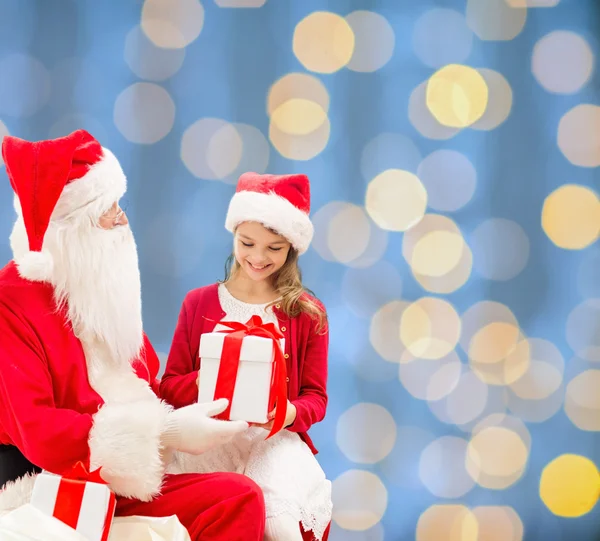 Sorrindo menina com Papai Noel e presentes — Fotografia de Stock