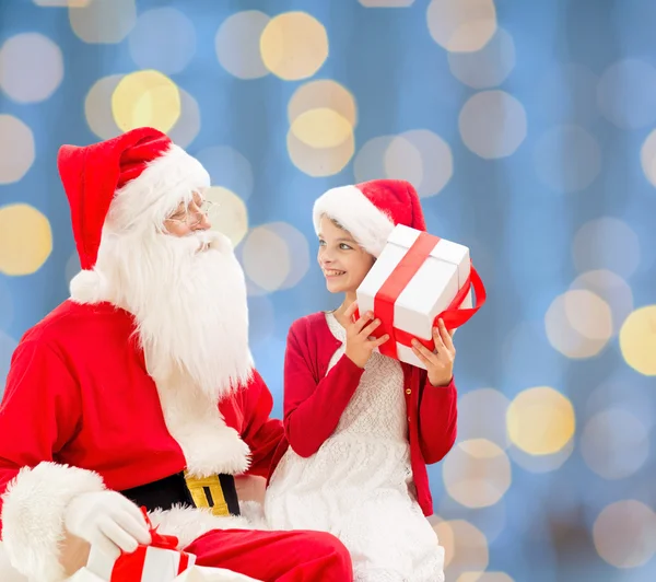 Niña sonriente con santa claus y regalos — Foto de Stock