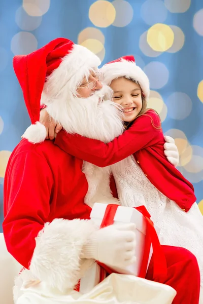 Lachende meisje met santa claus — Stockfoto