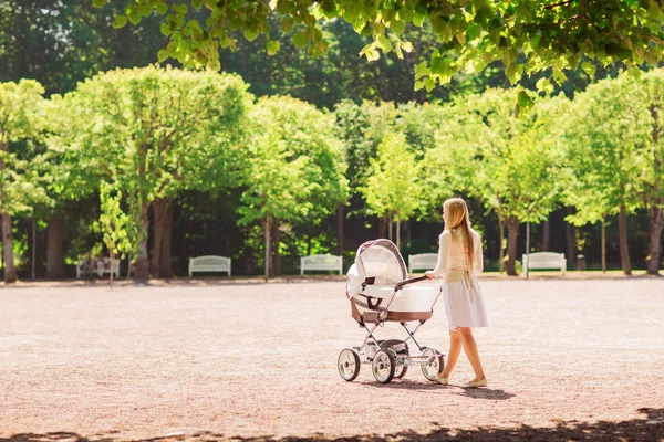 快乐母亲与婴儿小推车在公园里 — 图库照片