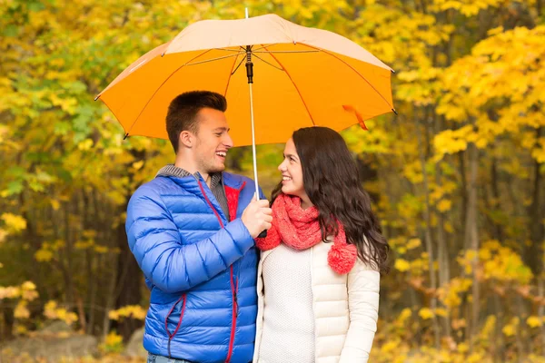 Sorrindo casal com guarda-chuva no parque de outono — Fotografia de Stock