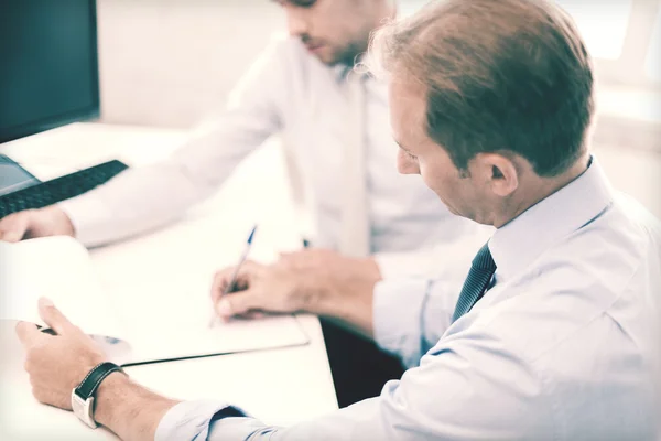 Empresarios con cuaderno sobre reunión — Foto de Stock