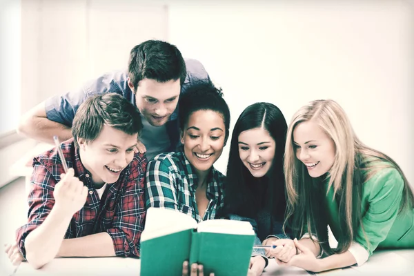 Estudiantes leyendo libro en la escuela — Foto de Stock