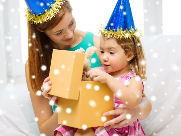 Mãe e filha em chapéus de festa com caixa de presente — Fotografia de Stock