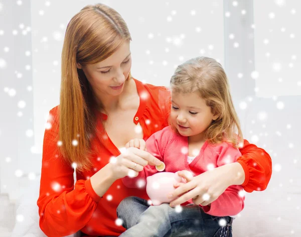 Mother and daughter with piggy bank — Stock Photo, Image