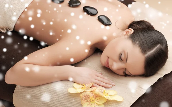 Kobieta w salonie spa z gorącymi kamieniami — Zdjęcie stockowe