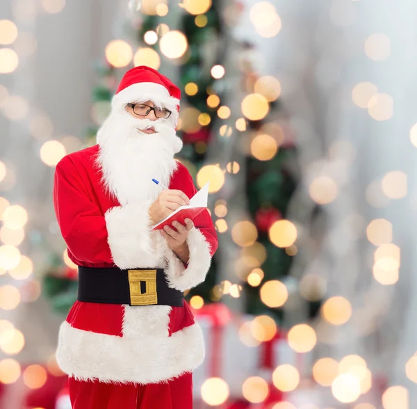 Mann im Weihnachtsmannkostüm mit Notizblock — Stockfoto