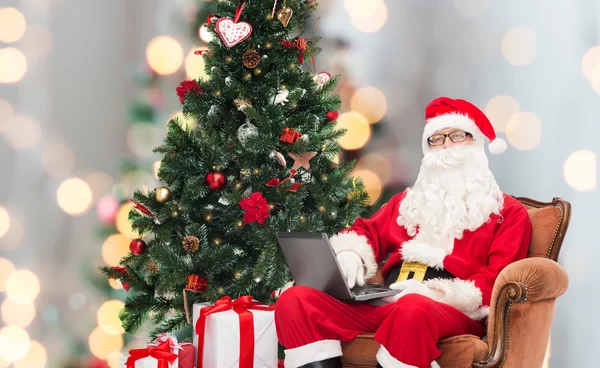 Man in kostuum van de kerstman met laptop — Stockfoto