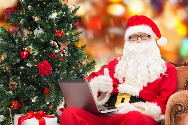 Man in kostuum van de kerstman met laptop — Stockfoto