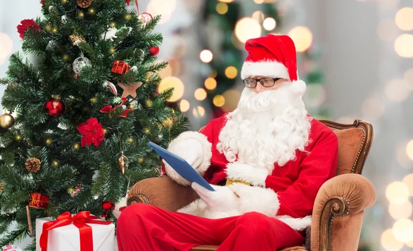 Man in costume of santa claus with tablet pc — Stock Photo, Image