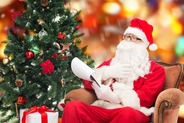 Man in costume of santa claus with notepad — Stock Photo, Image