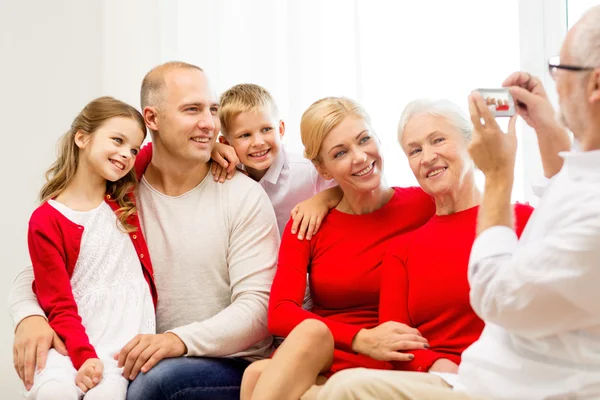 Улыбающаяся семья с камерой дома — стоковое фото