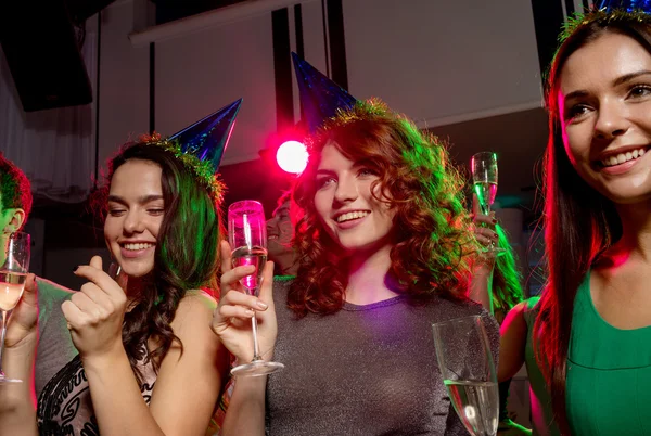 Lachende vrienden met glazen van champagne in club — Stockfoto